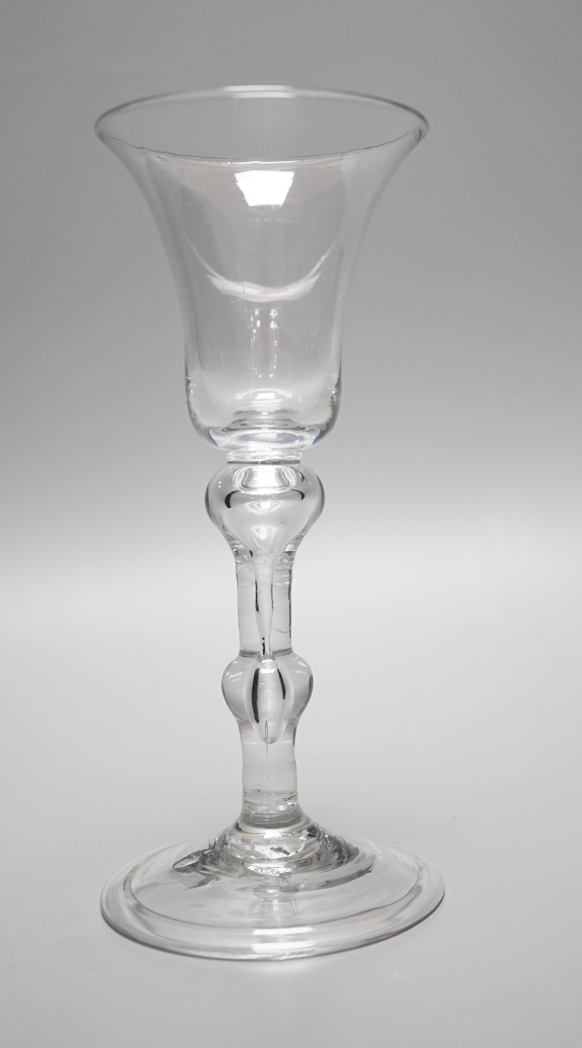 A George II balustroid folded foot glass, 15.5cm tall